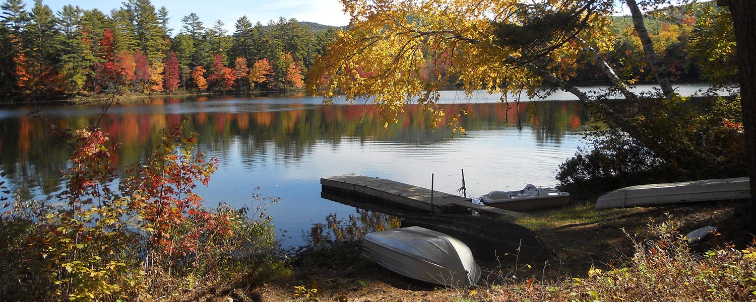 boats and dock on lake luzerne ny in the fall